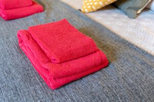 neatly folded red towels on bed in apartment